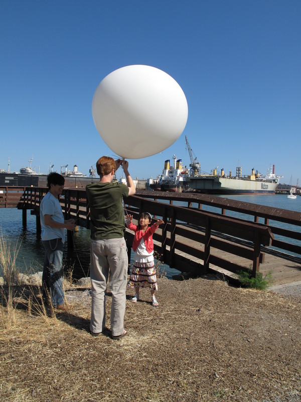 Mark grabs the gondola and secures the balloon.