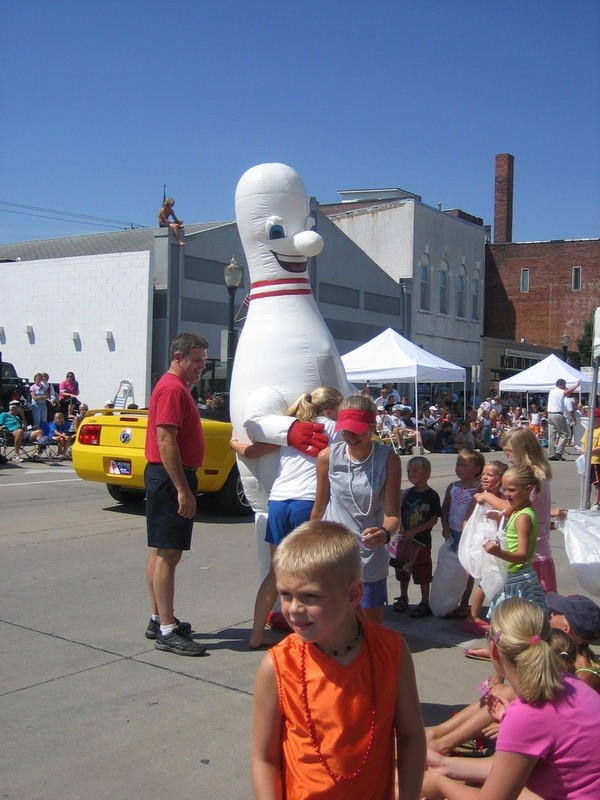 Bowling pin mascot guy hugging kids