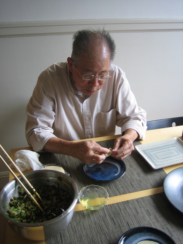 Dad demonstrates how to form a potsticker.